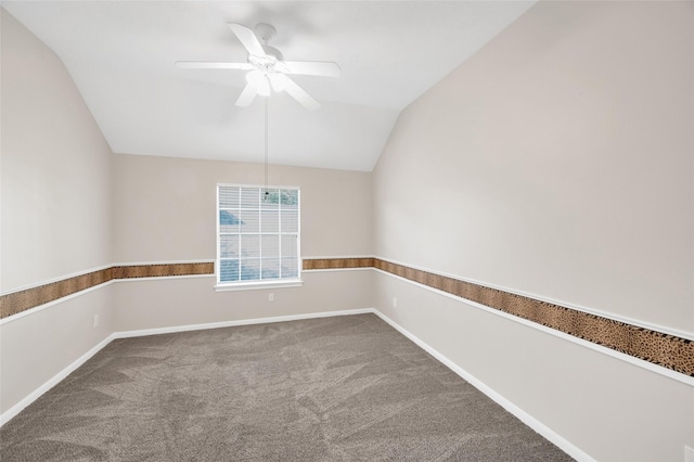 carpeted empty room with vaulted ceiling, ceiling fan, and baseboards