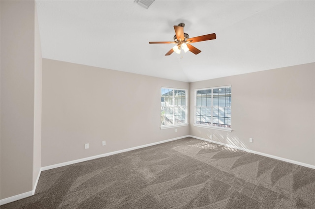 empty room featuring lofted ceiling, carpet flooring, a ceiling fan, visible vents, and baseboards