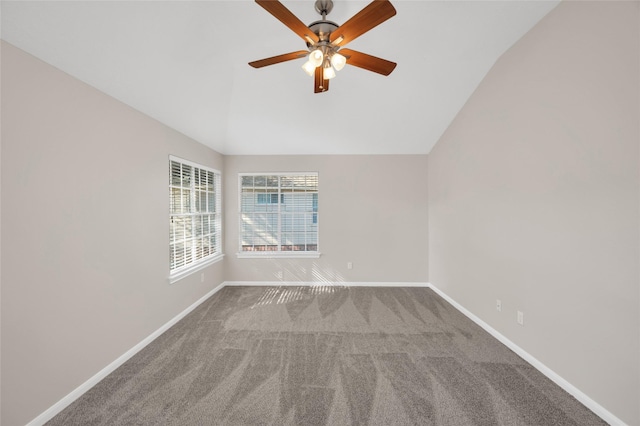 carpeted spare room featuring vaulted ceiling, baseboards, and ceiling fan