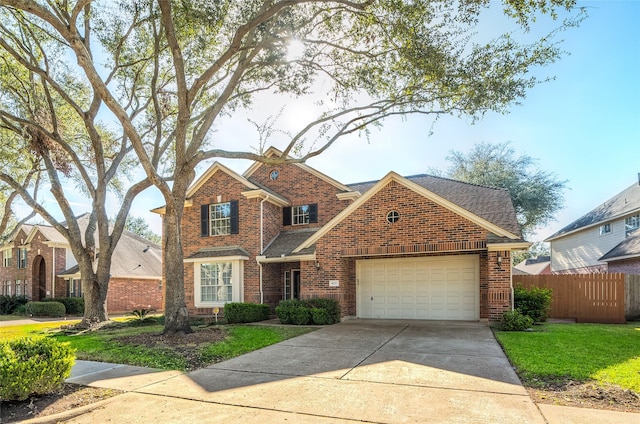 traditional-style house featuring a garage, brick siding, fence, concrete driveway, and a front yard