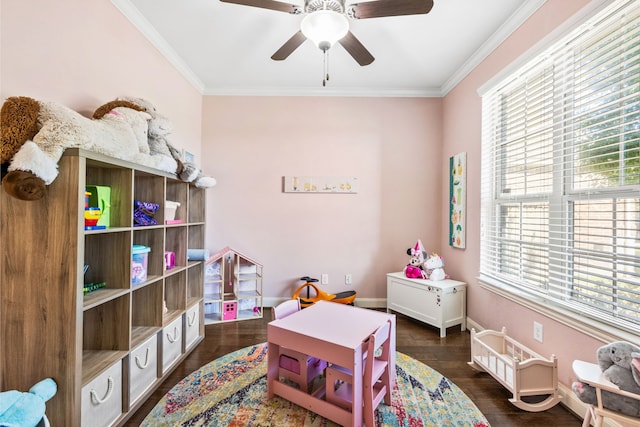 game room with a ceiling fan, dark wood-style flooring, crown molding, and baseboards