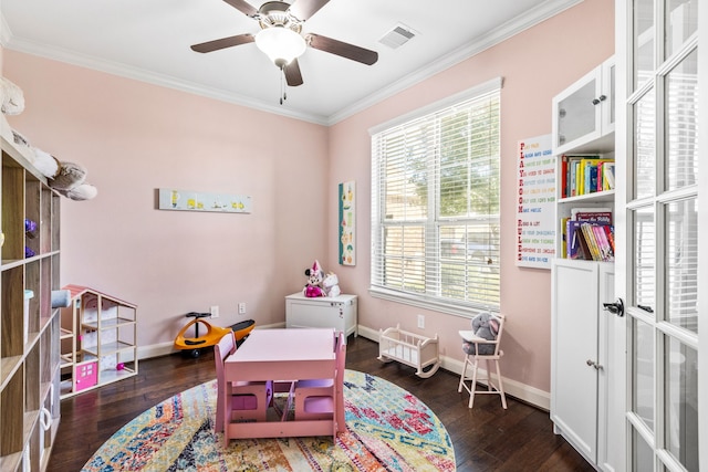 playroom with dark wood-style floors, visible vents, crown molding, and baseboards