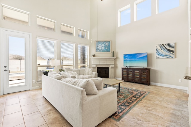 living room featuring baseboards and a glass covered fireplace