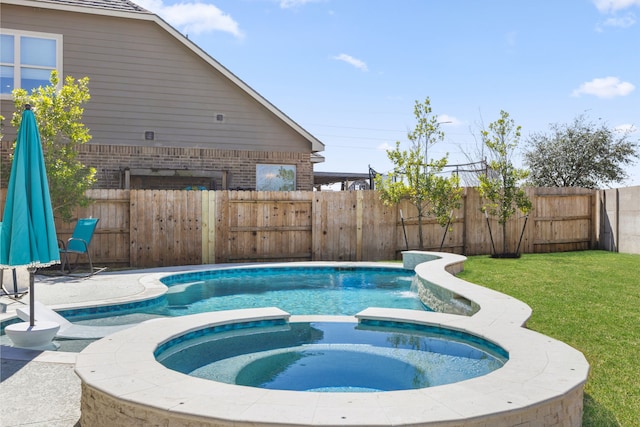 view of swimming pool featuring a pool with connected hot tub, a fenced backyard, and a yard