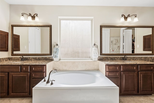 full bath with a garden tub, two vanities, and a sink