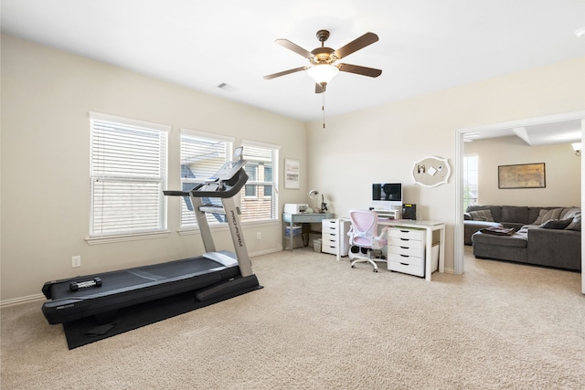 workout area with a ceiling fan, light colored carpet, visible vents, and baseboards