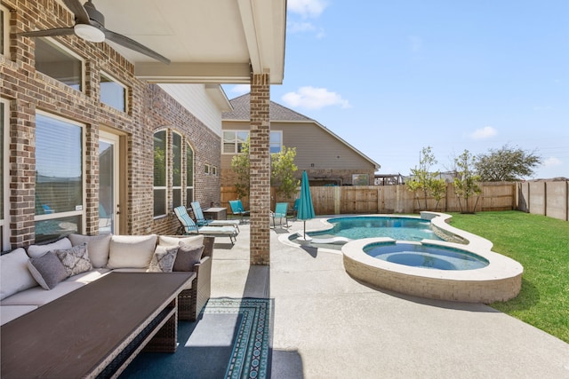 view of pool with a patio, a fenced backyard, an outdoor hangout area, a pool with connected hot tub, and a ceiling fan