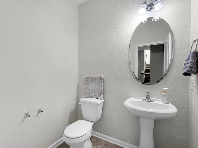 half bath with toilet and baseboards