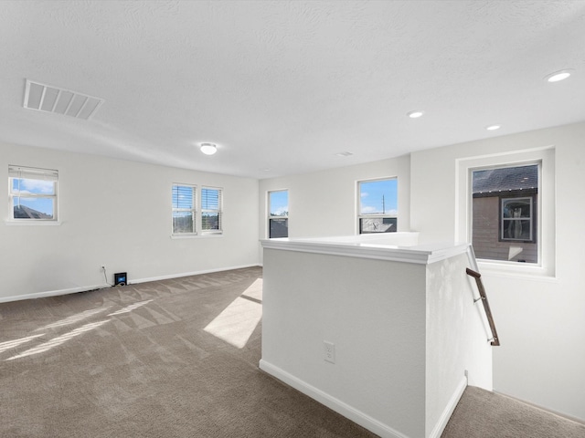 interior space with a healthy amount of sunlight, visible vents, a textured ceiling, and baseboards