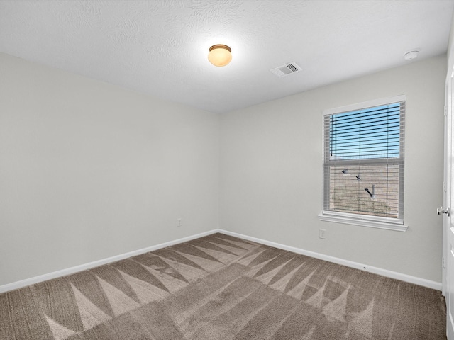 carpeted spare room with a textured ceiling, visible vents, and baseboards