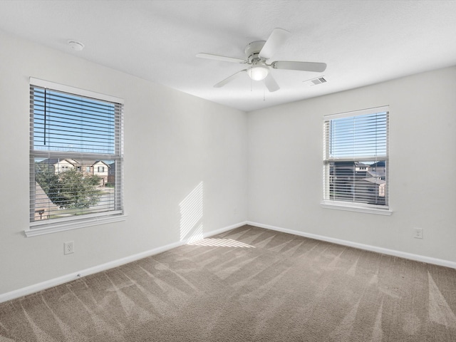 empty room featuring baseboards, visible vents, ceiling fan, and carpet flooring