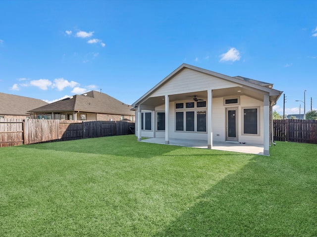 back of property featuring a ceiling fan, a patio area, a yard, and a fenced backyard