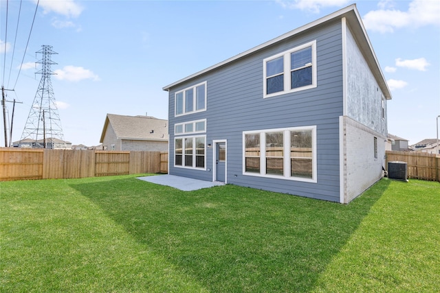 rear view of house featuring a patio area, a fenced backyard, central AC unit, and a yard