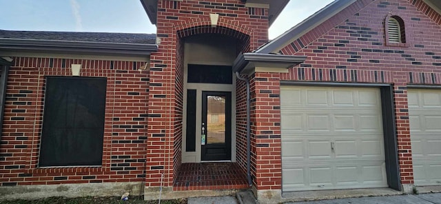 entrance to property featuring brick siding and an attached garage