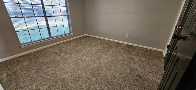 empty room featuring carpet flooring and baseboards