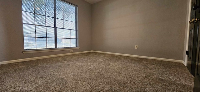 carpeted empty room featuring baseboards