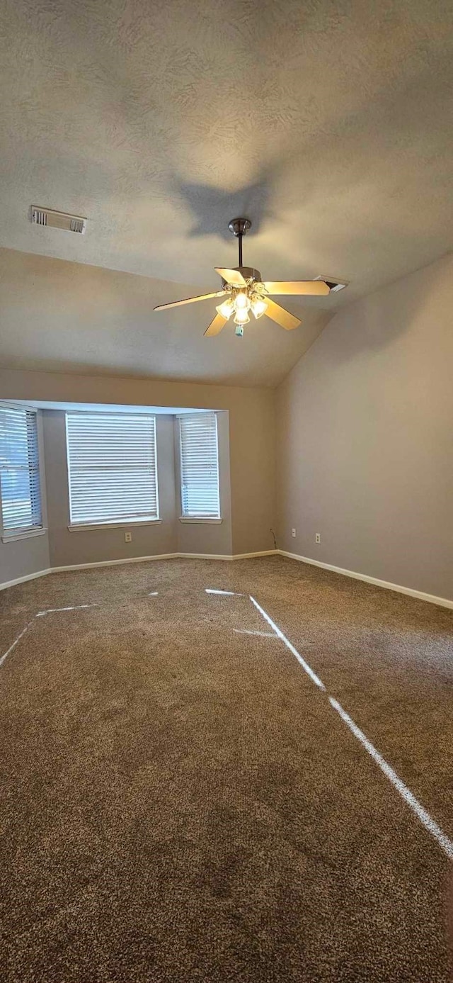 empty room with a textured ceiling, ceiling fan, visible vents, baseboards, and carpet