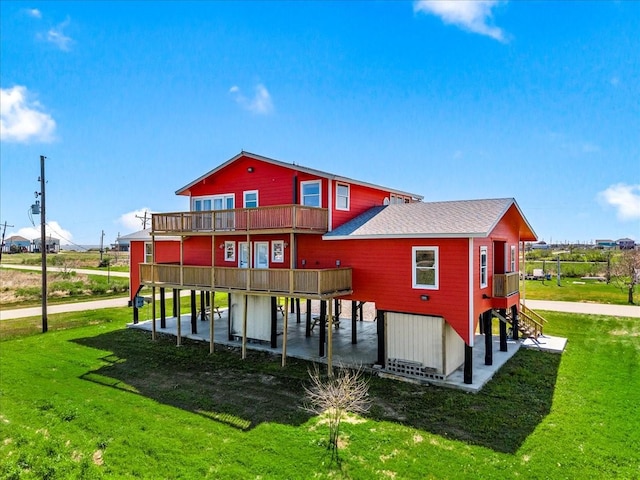 rear view of property with a lawn and a shingled roof