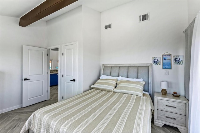 bedroom with beam ceiling and visible vents