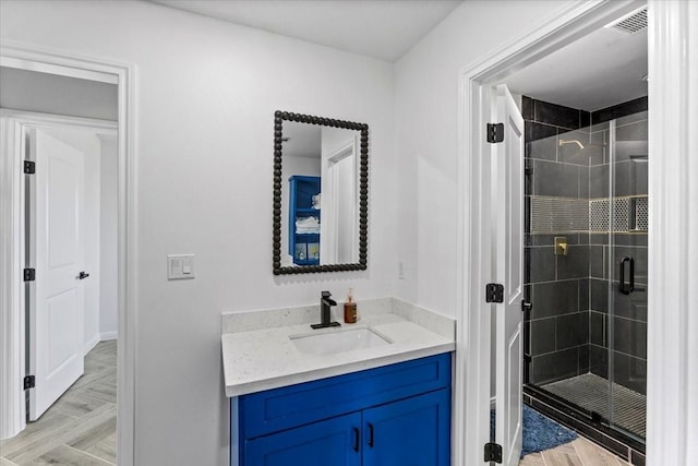 bathroom with visible vents, a stall shower, and vanity