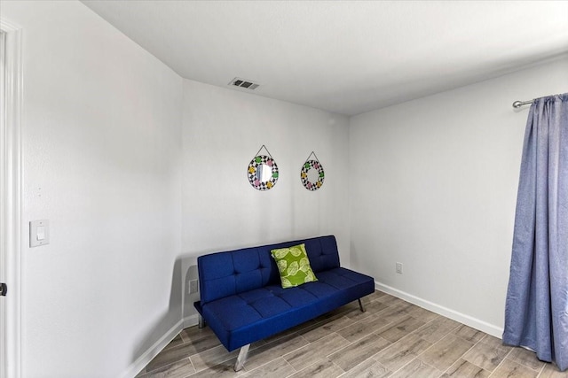 living area featuring visible vents, baseboards, and wood finished floors