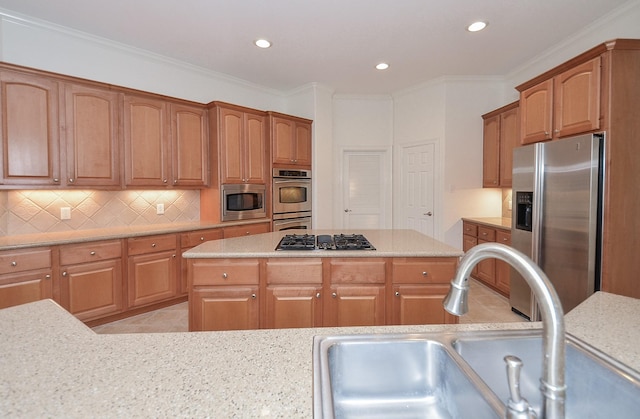 kitchen featuring appliances with stainless steel finishes, a sink, backsplash, and light stone countertops