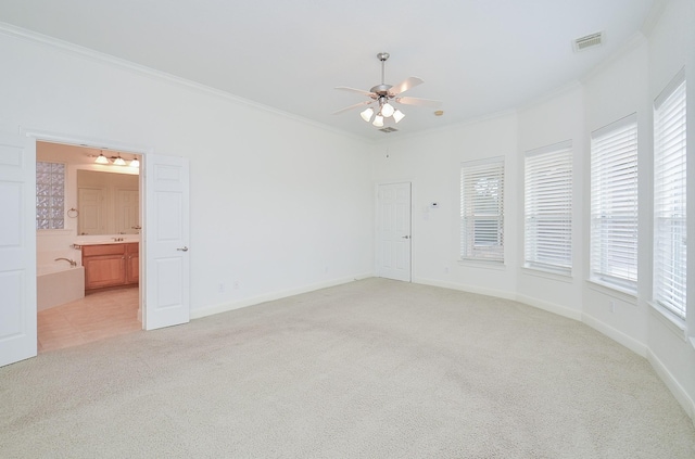 unfurnished room with light colored carpet, visible vents, ornamental molding, ceiling fan, and baseboards