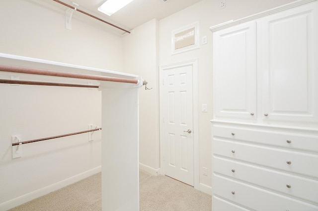 walk in closet featuring light carpet