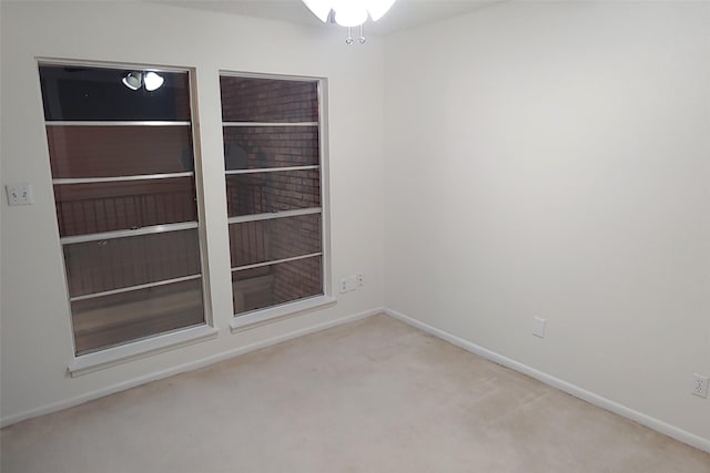 unfurnished room with baseboards and light colored carpet