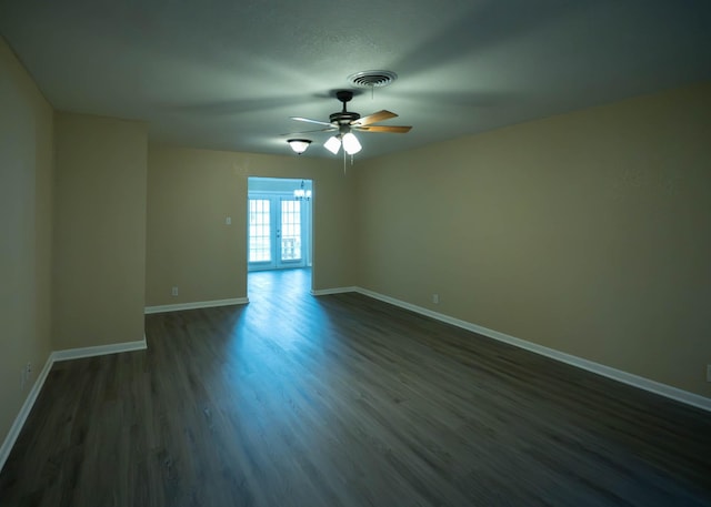 unfurnished room with visible vents, baseboards, dark wood finished floors, and ceiling fan with notable chandelier