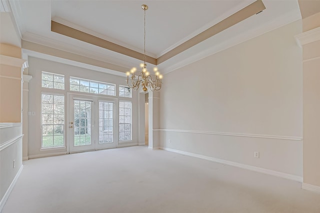 carpeted spare room with crown molding, a tray ceiling, and a healthy amount of sunlight