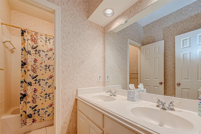 bathroom featuring double vanity, wallpapered walls, shower / bath combo with shower curtain, and a sink