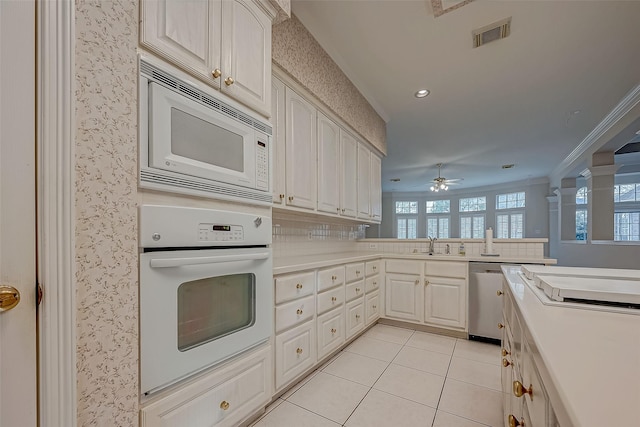 kitchen featuring white appliances, light tile patterned floors, visible vents, a peninsula, and light countertops