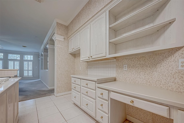 kitchen featuring crown molding, open shelves, light countertops, light tile patterned flooring, and wallpapered walls