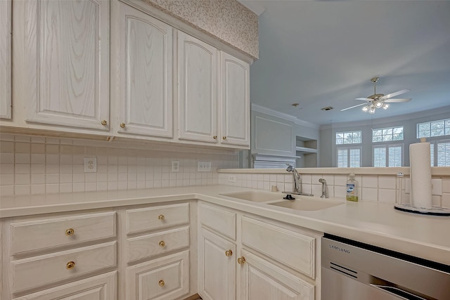 kitchen featuring dishwasher, light countertops, tasteful backsplash, and a sink