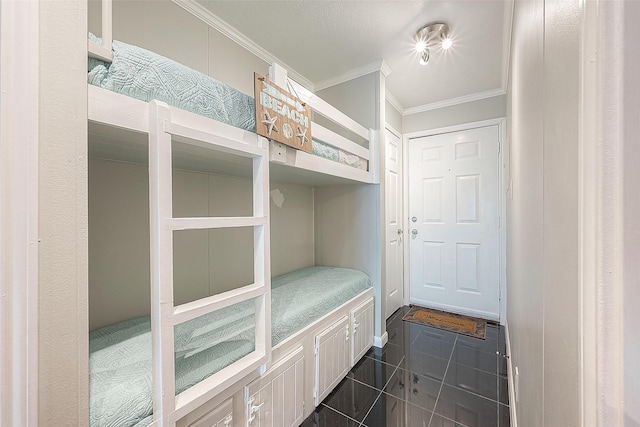 mudroom featuring crown molding and dark tile patterned floors