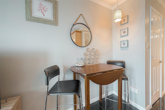 dining space featuring baseboards and crown molding