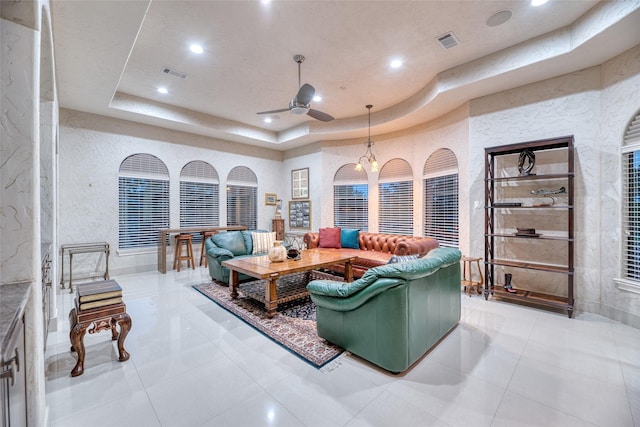 living area with recessed lighting, a raised ceiling, and visible vents