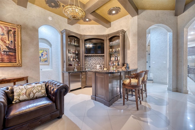 bar with arched walkways, pendant lighting, beam ceiling, wet bar, and fridge