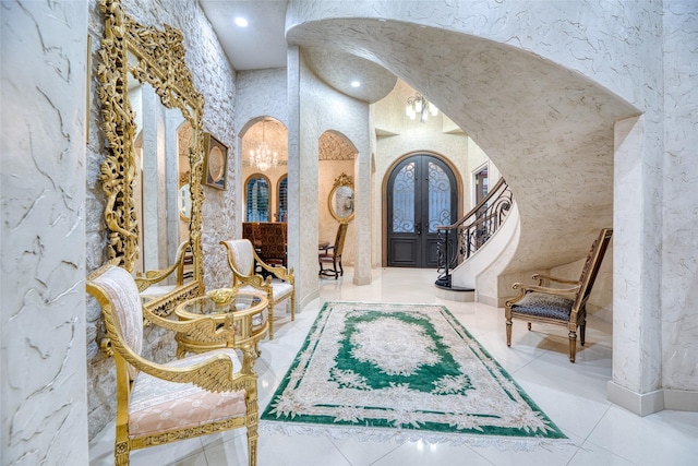 living area featuring arched walkways, french doors, a towering ceiling, and stairs