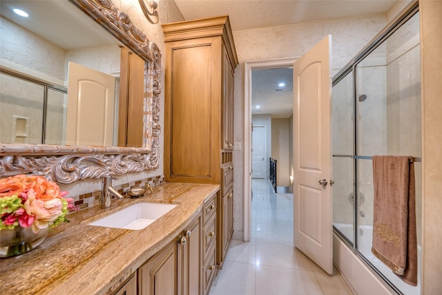 full bath with bath / shower combo with glass door, recessed lighting, tile patterned floors, vanity, and wallpapered walls