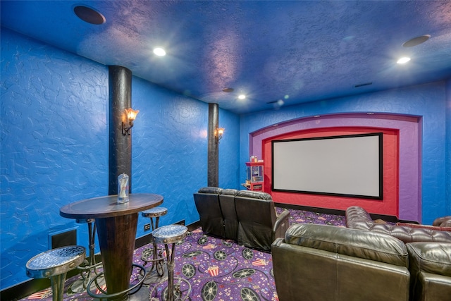 cinema featuring recessed lighting, visible vents, a textured wall, and a textured ceiling