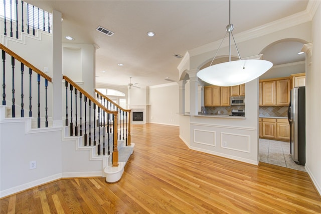 kitchen with a fireplace, light wood finished floors, visible vents, appliances with stainless steel finishes, and open floor plan