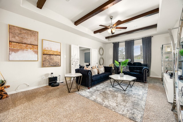 carpeted living area with a ceiling fan, a raised ceiling, baseboards, and beam ceiling