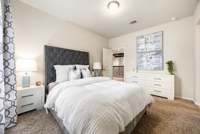 bedroom with dark carpet, visible vents, and baseboards