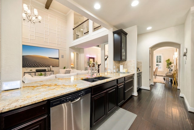 kitchen with dark wood finished floors, hanging light fixtures, open floor plan, a sink, and dishwasher