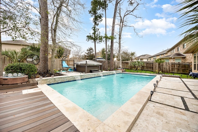 view of swimming pool with a fenced in pool, a fenced backyard, a wooden deck, and a hot tub