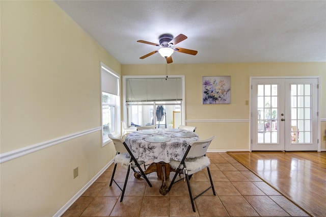 tiled dining space featuring french doors, plenty of natural light, and baseboards