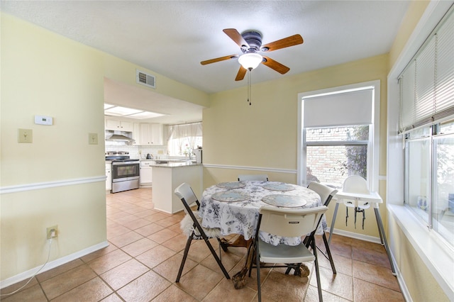 dining space with baseboards, visible vents, ceiling fan, and light tile patterned flooring