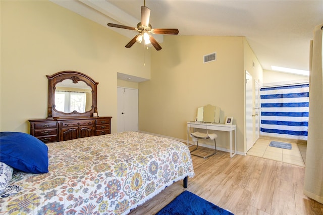 bedroom with light wood-style flooring, visible vents, baseboards, vaulted ceiling, and a ceiling fan